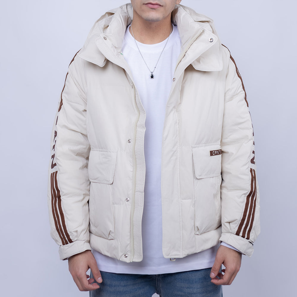 Person wearing a beige puffer jacket with brown stripes on a light gray background