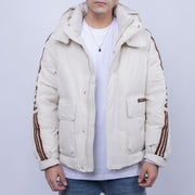 Person wearing a beige puffer jacket with brown stripes on a light gray background